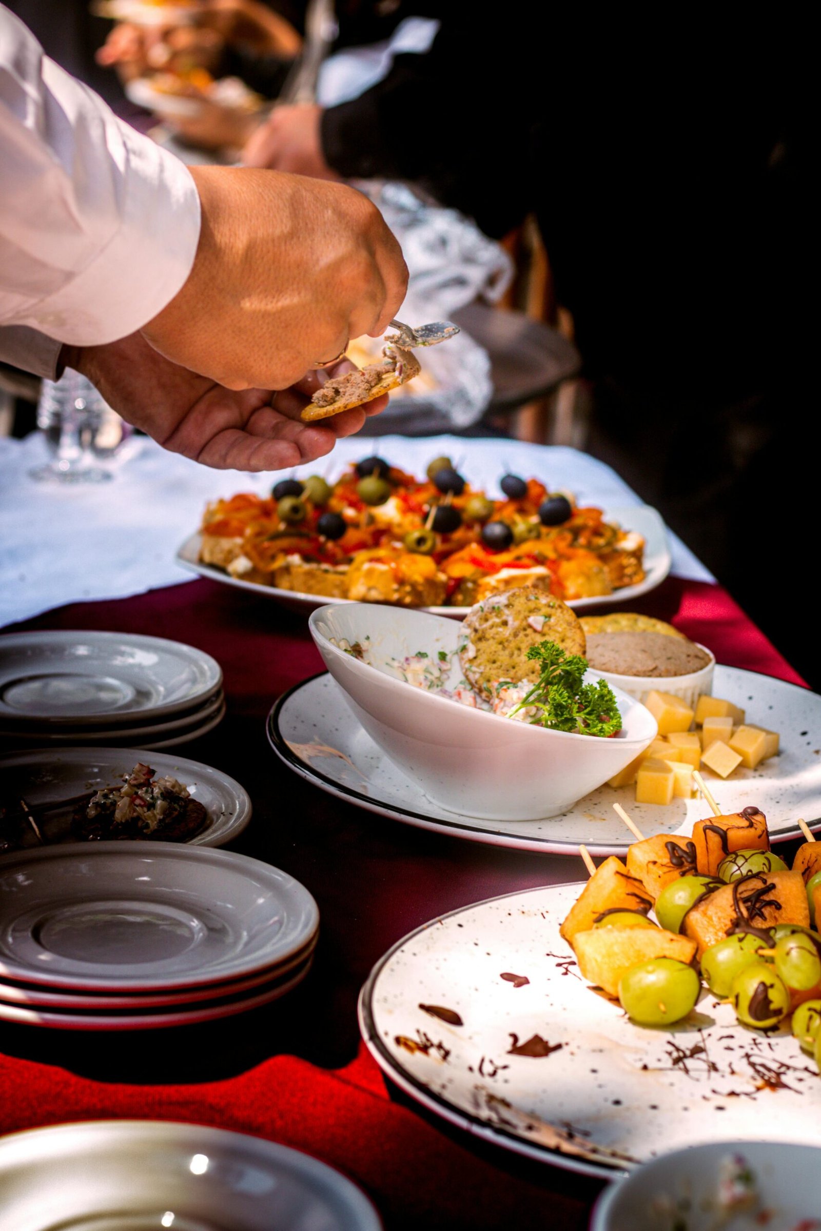 Close-up of a buffet table with diverse appetizers, fruits, and cheese.
